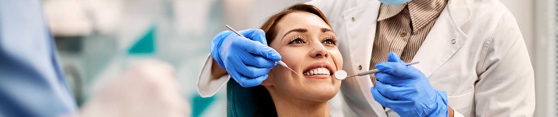 A well-lit reception area with a desk, computer monitor, and potted plant.